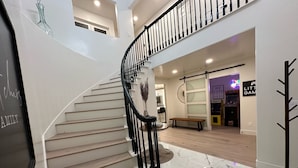 A staircase with a black railing leading to a second floor. - Sleeps 50+ NEW Luxury Private Resort with Pool Golf Arcade Spa Playground Poker (Lakeside)