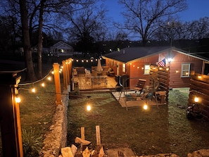 A wooden deck with string lights, a grill, and outdoor furniture. - Downtown Cotter Retreat -- Great Outdoor Space!! 200 feet of String Lights! (Cotter)