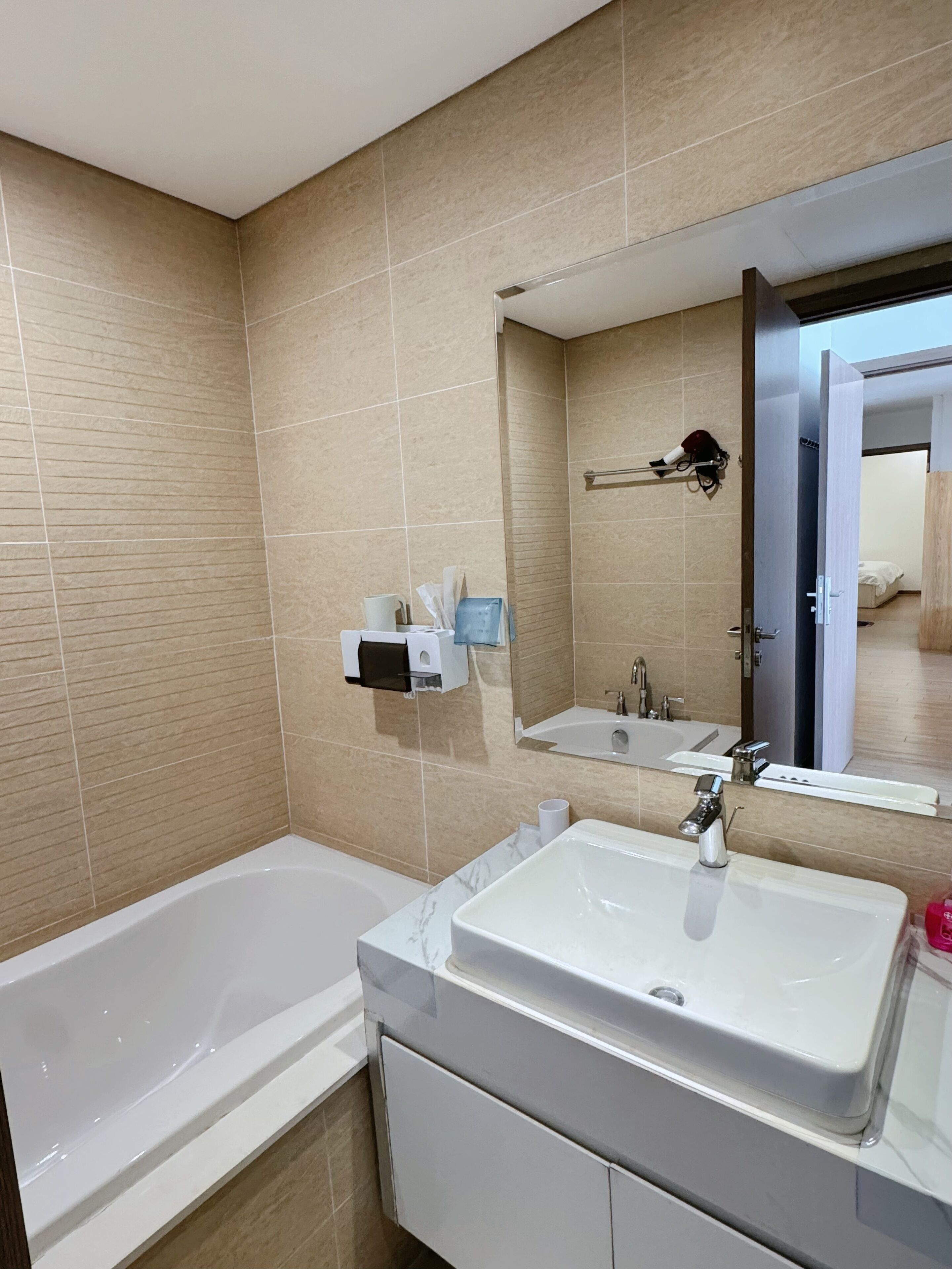 Un bagno moderno con una vasca, un mobile lavabo e un grande specchio.
