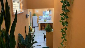 A narrow hallway with a kitchen area at the end, featuring a refrigerator, sink, and countertop with plants. - Story Villa, 2 Bedrooms with Mountain & Ocean View (Canaries)