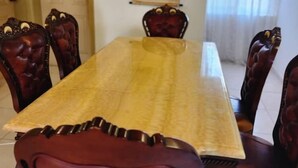 A dining area with a long table and six upholstered chairs. - 3 Bed House - Sleeps 9 - Pets - Garden - Parking (Accra)