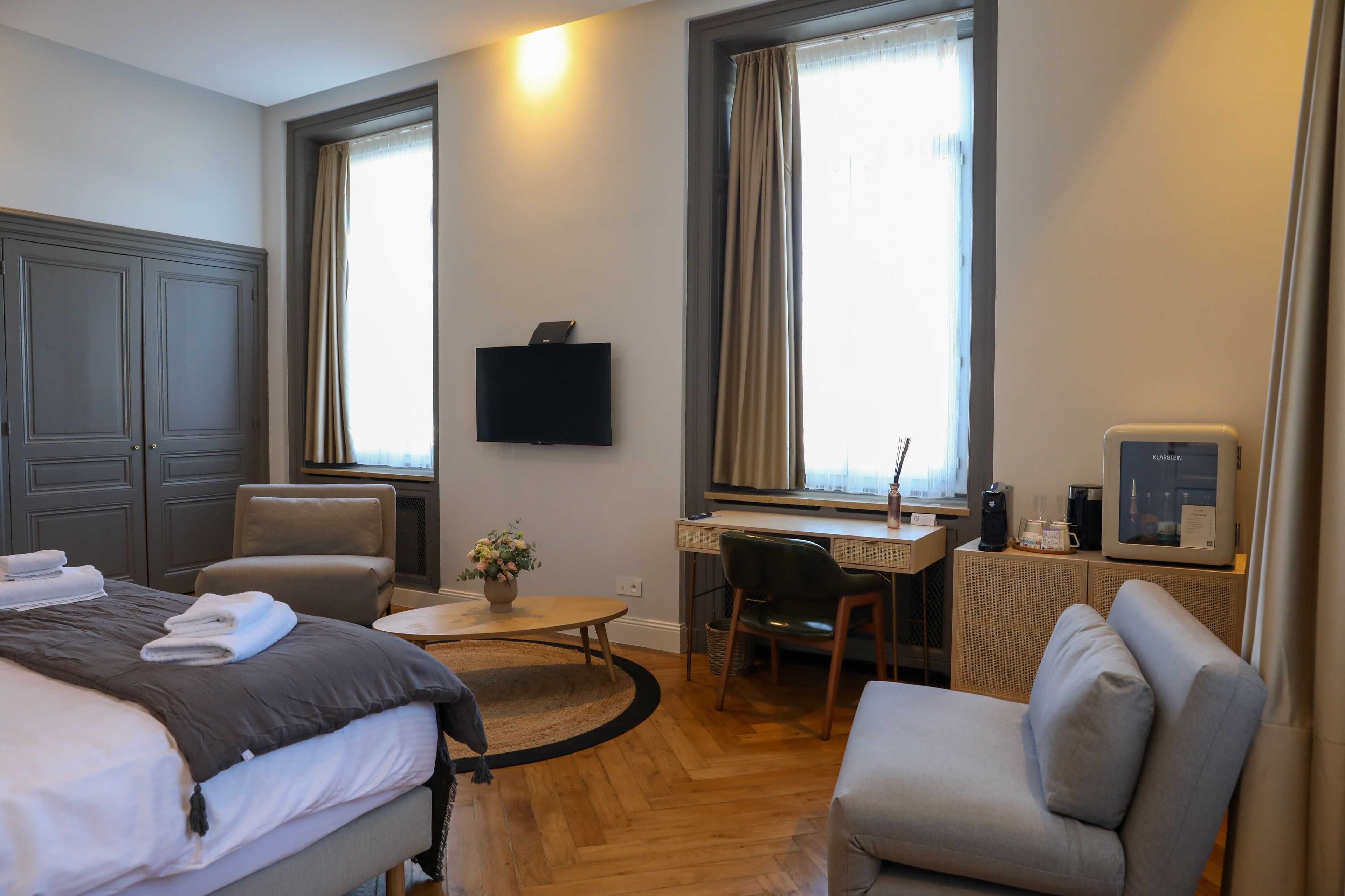 Una camera d'albergo con un letto, una scrivania, una sedia, una televisione e una macchina del caffè.