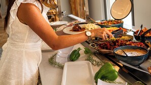 Un buffet con diversi piatti e una persona che serve cibo.