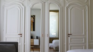 Una stanza con uno specchio grande, un letto, una scrivania e una sedia.