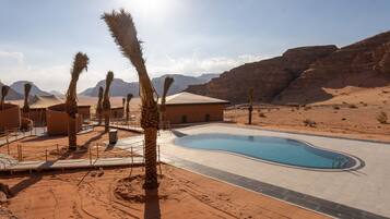 Una piscina al aire libre, sombrillas, tumbonas