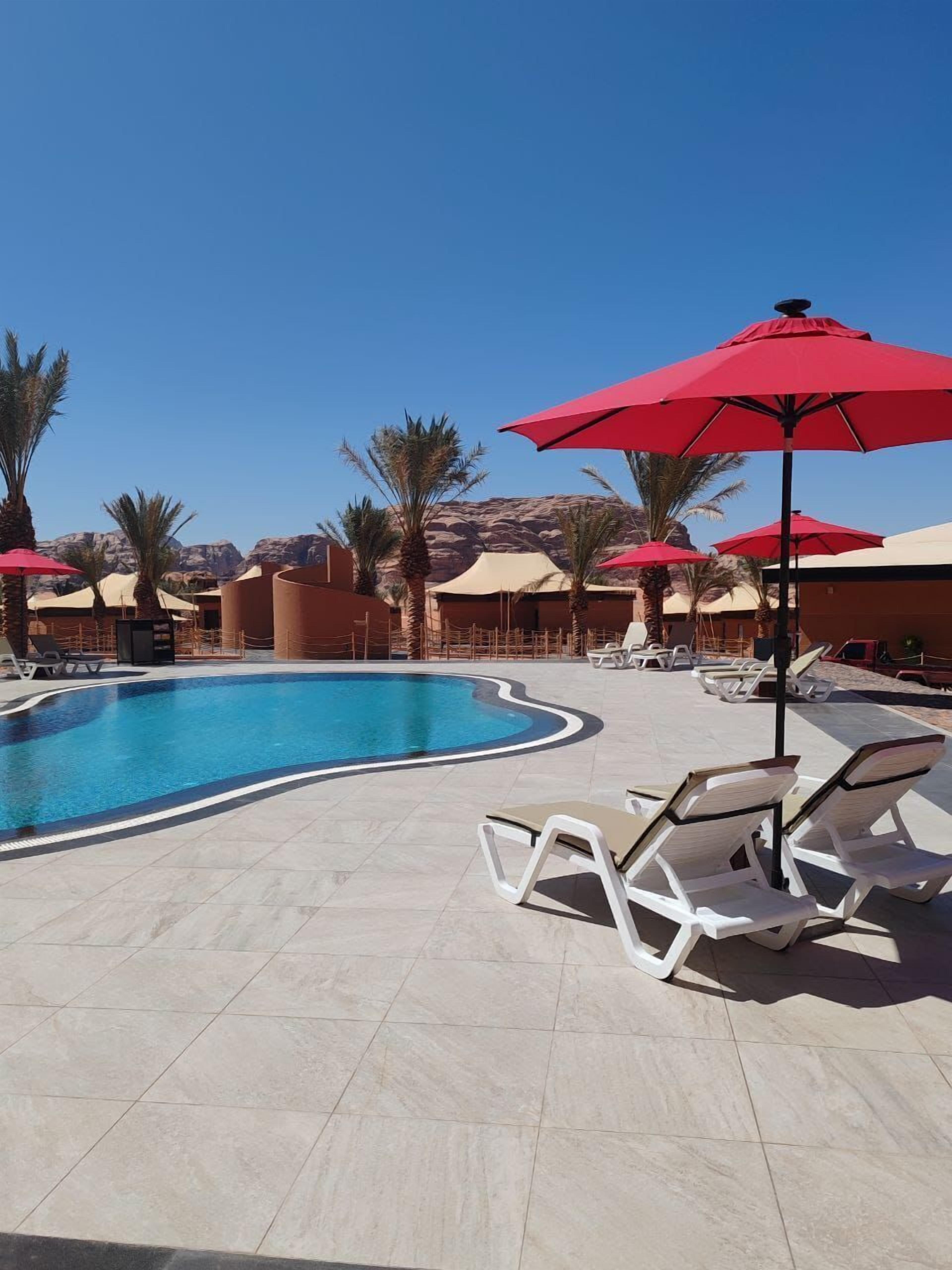 Alberca al aire libre, sombrillas en la alberca y camastros 