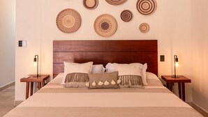 A neatly arranged bedroom with a wooden headboard, a large bed with multiple pillows, and wall-mounted woven art pieces. - Spectacular House with private pool and garage (Mérida)