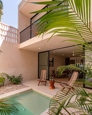 A modern outdoor space with a pool, seating area, and a balcony with a railing. - Spectacular House with private pool and garage (Mérida)