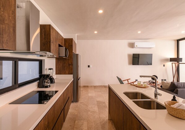 A modern kitchen with wooden cabinets, a built-in stove, and a large island with a sink. - Spectacular House with private pool and garage (Mérida)