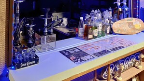 A bar area with a chalkboard menu, various bottles, and a wooden sign. - Hotel1800 (Minamiuonuma)