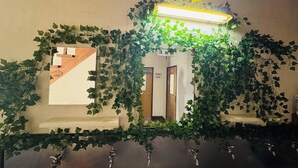 A mirror with ivy covering it, a light above the mirror, and a set of keys below. - Hotel1800 (Minamiuonuma)