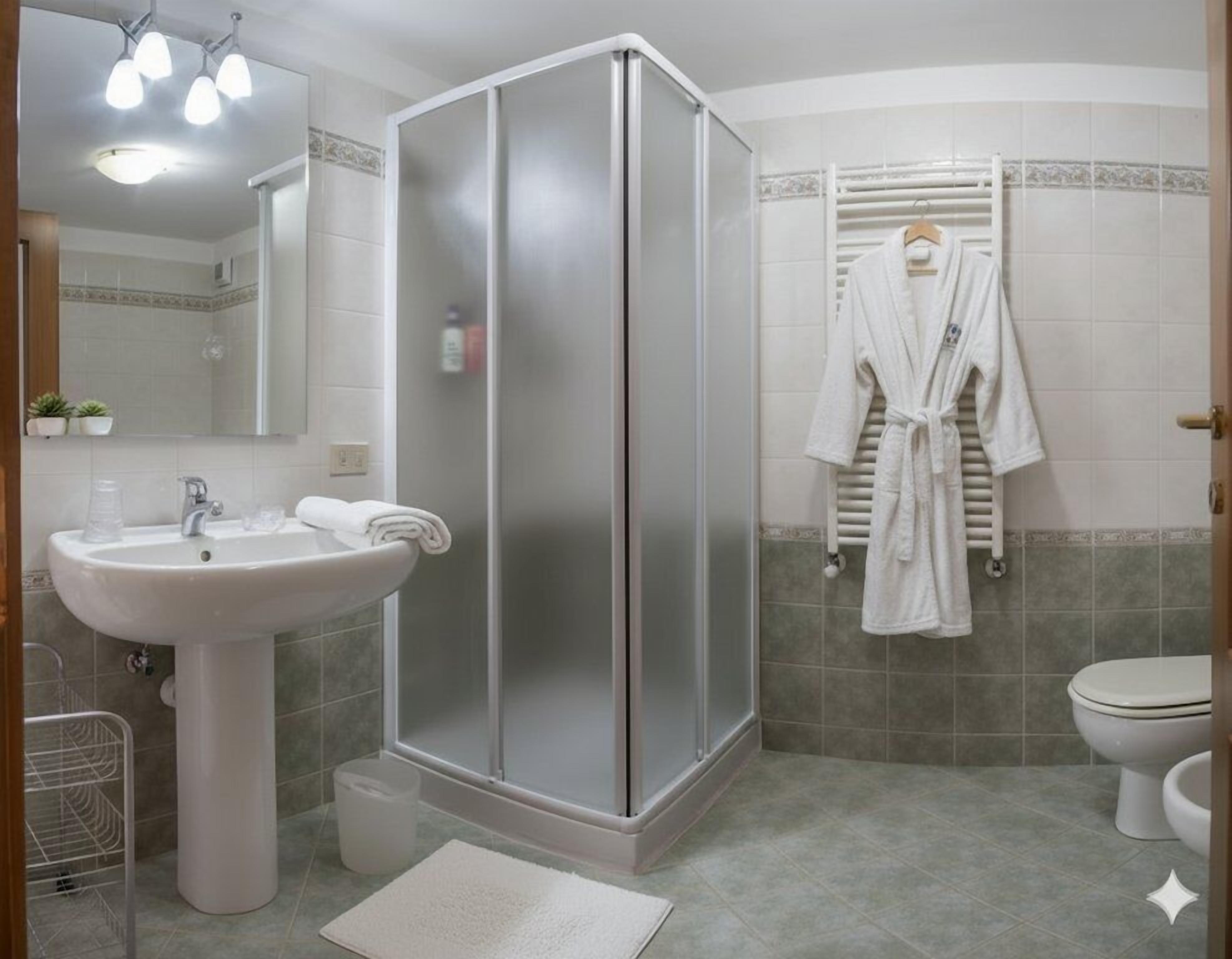 A bathroom with a shower, sink, and toilet.