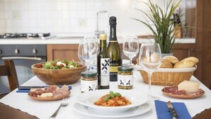 Ein Esstisch mit verschiedenen Gerichten, Wein und Brot gedeckt.