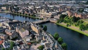 Une ville riveraine dotée de bâtiments historiques, d’un pont et d’un château.