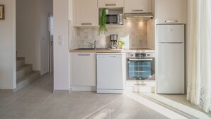 A modern kitchen with white cabinetry, a built-in microwave, a stove, and a dishwasher.