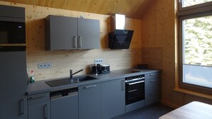 Una cucina moderna con mobili grigi, lavastoviglie, microonde e forno.