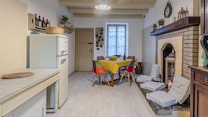 Una cocina compacta con comedor, refrigerador empotrado y chimenea.