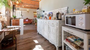 A kitchen with a white cabinet, a microwave, and a wooden table. - Helix1912 by Interhome (San Damiano d'Asti)