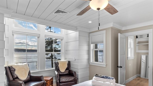 A spacious room with large windows, a ceiling fan, and a view of the outdoors. - Lady of The Lake (Laconia)