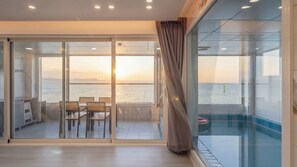 Un balcón con vistas al mar y al horizonte urbano al atardecer.