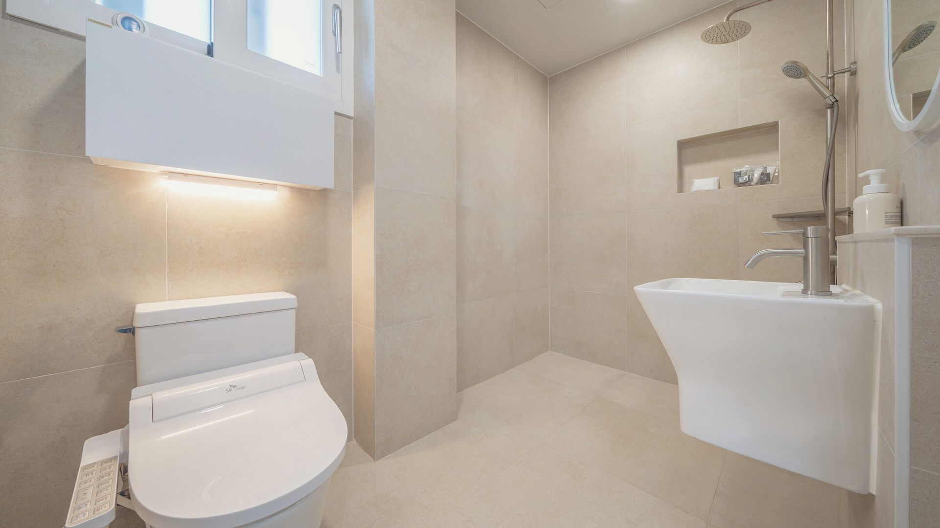 A modern bathroom with a toilet, shower, and sink.
