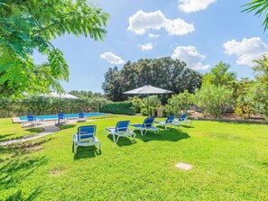 A poolside area with lounge chairs and umbrellas. - Can Camarroja by Sunvillas Mallorca (Pollença)