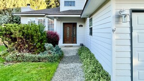 A two-story house with a front porch, a mailbox, and a well-maintained garden. - Hot tub + Bright and spacious home + 20 min to Ski —> Sleeps 13! (East Wenatchee)