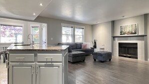 A modern kitchen with a granite countertop, white cabinetry, and a built-in oven. - Hot tub + Bright and spacious home + 20 min to Ski —> Sleeps 13! (East Wenatchee)