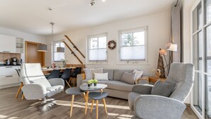 A modern living room with a sofa, chairs, a coffee table, and a dining area with a table and chairs. - Luxury apartment with terrace near Kaprun (Piesendorf)