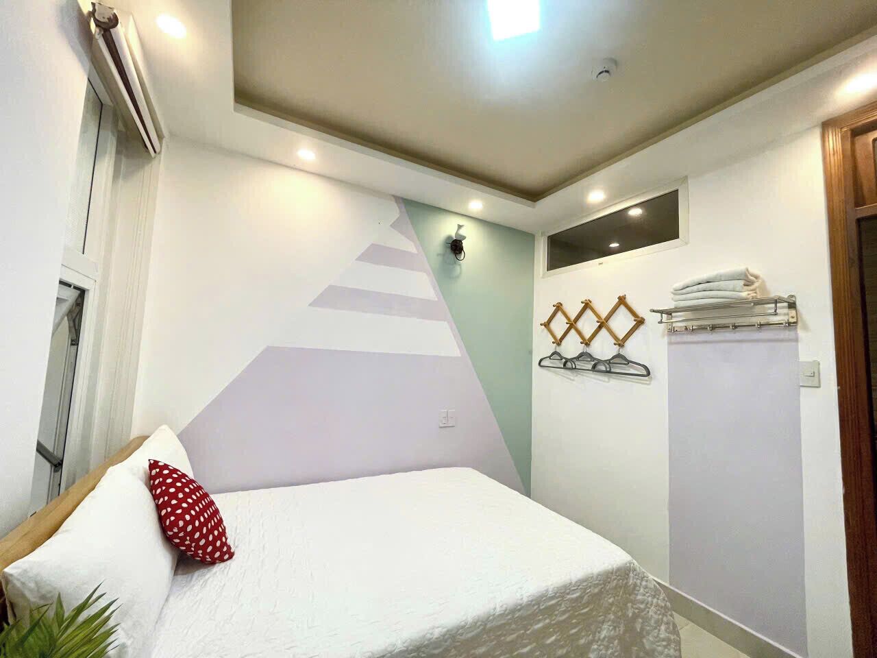 Ein Schlafzimmer mit einem Bett, einem Wandheizkörper, einem Handtuchhalter und einem Fenster.
