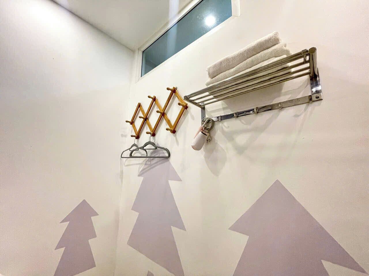 A bathroom with a towel rack, a towel warmer, and a wall with mountain silhouettes.
