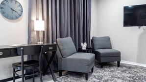A modern room with a desk, two chairs, a TV, and a clock on the wall. - Montrose Chelsea Studio! Medical Center 10 (Houston)