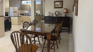 A spacious living area with a dining table, chairs, a kitchen in the background, and a decorative lamp. - Anping Ease (Tainan)