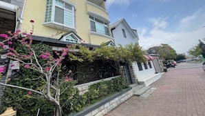 A residential building with a yellow facade, white trim, and a balcony. - Anping Ease (Tainan)