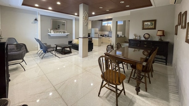 A spacious living area with a dining table, chairs, a kitchen, and a seating area with a sofa and chairs. - Anping Ease (Tainan)