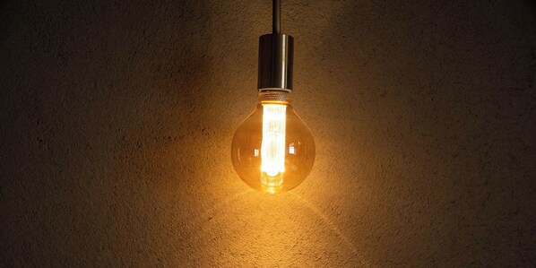 A single light bulb hanging from a ceiling.