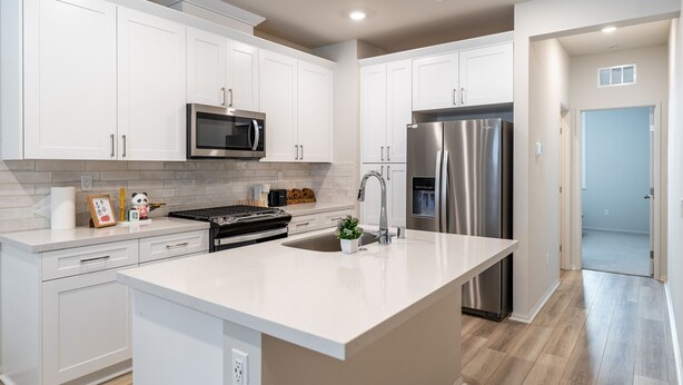 A modern kitchen with white cabinets, stainless steel appliances, and a large island. - Brand New 3b3b Condo in the heart of West Covina (West Covina)