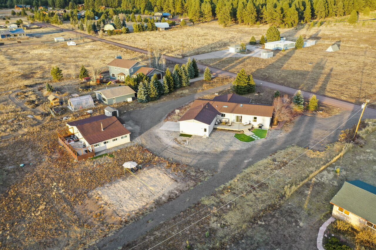 An aerial view of a residential area with houses, roads, and surrounding vegetation.