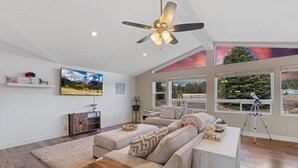 A spacious living room with a large sectional sofa, a ceiling fan, and a telescope on a tripod. - Large Groups, Volleyball Court, Large Space (Flagstaff)
