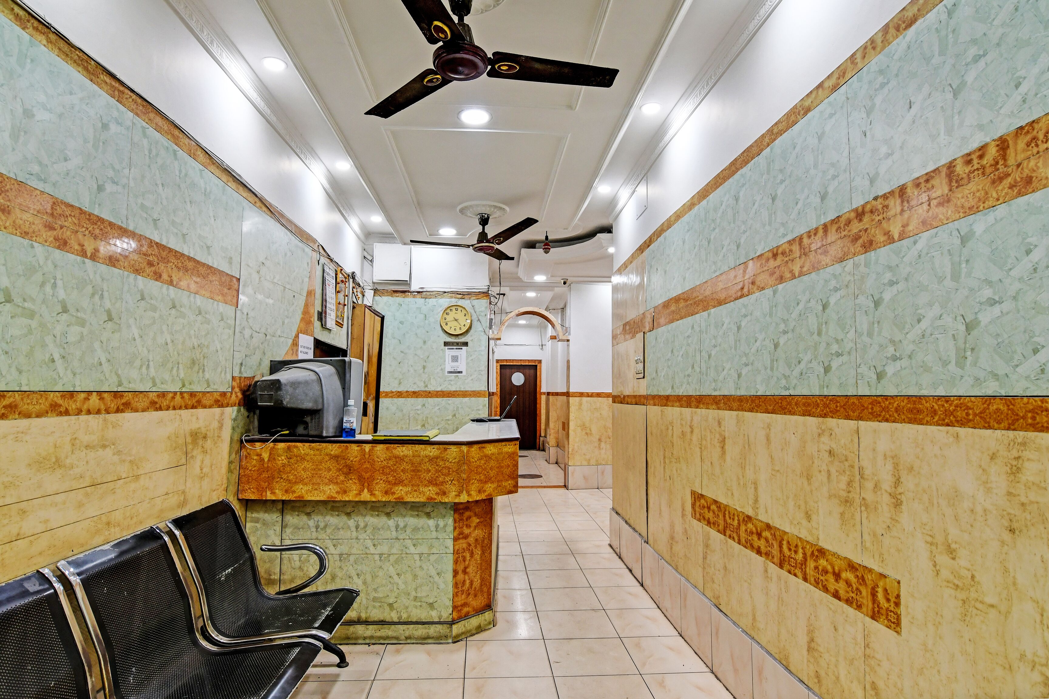 A reception area with a counter, chairs, and a ceiling fan.
