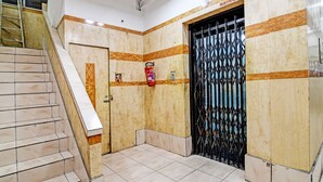 A staircase leading to a room with a tiled floor and a door with a metal gate. - Hotel Dinar (Kolkata)