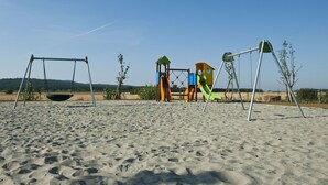 A playground with swings and climbing structures on a sandy beach. - Cosy apartment for 6 people with A/C, pool, TV, patio and panoramic view (Casalappi)