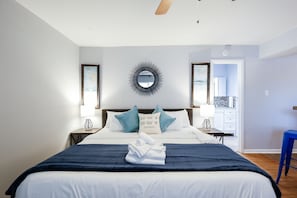 A hotel room with a bed, a nightstand, a mirror, and a view of the bathroom. - Montrose Dashing Studio! Medical Center 26 (Houston)