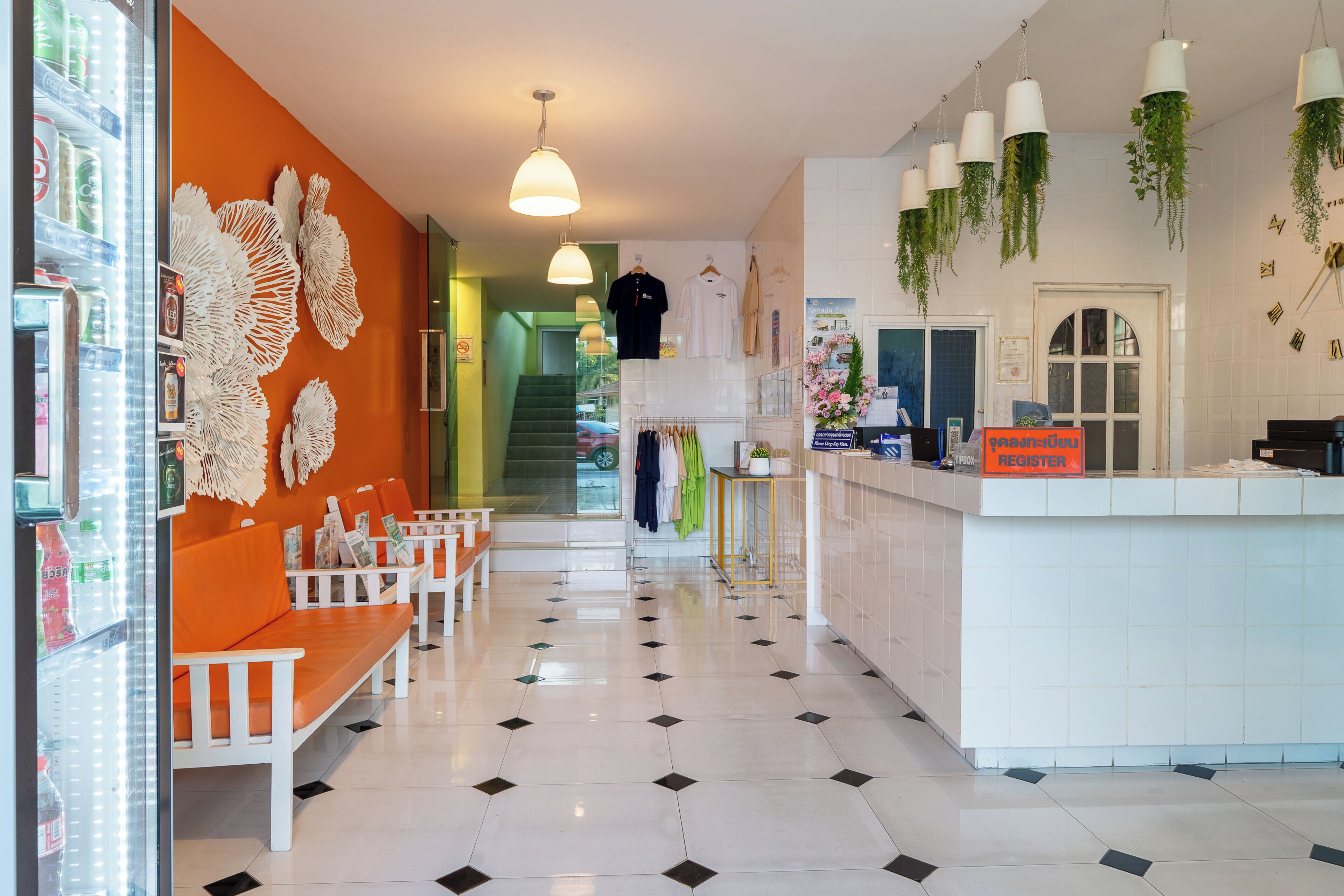 Eine Hotelhalle mit Empfangstresen, Sitzgelegenheiten und einer Treppe zu den oberen Stockwerken.
