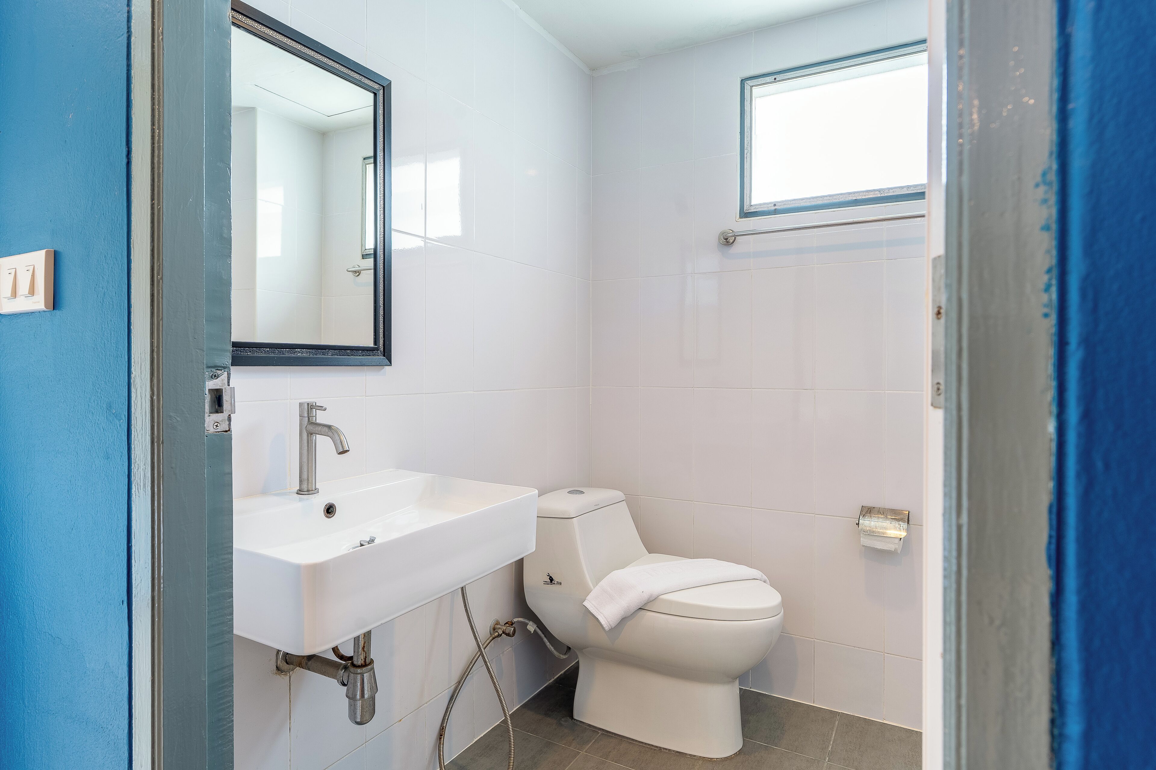 Un bagno con un lavandino bianco, un water e uno specchio.
