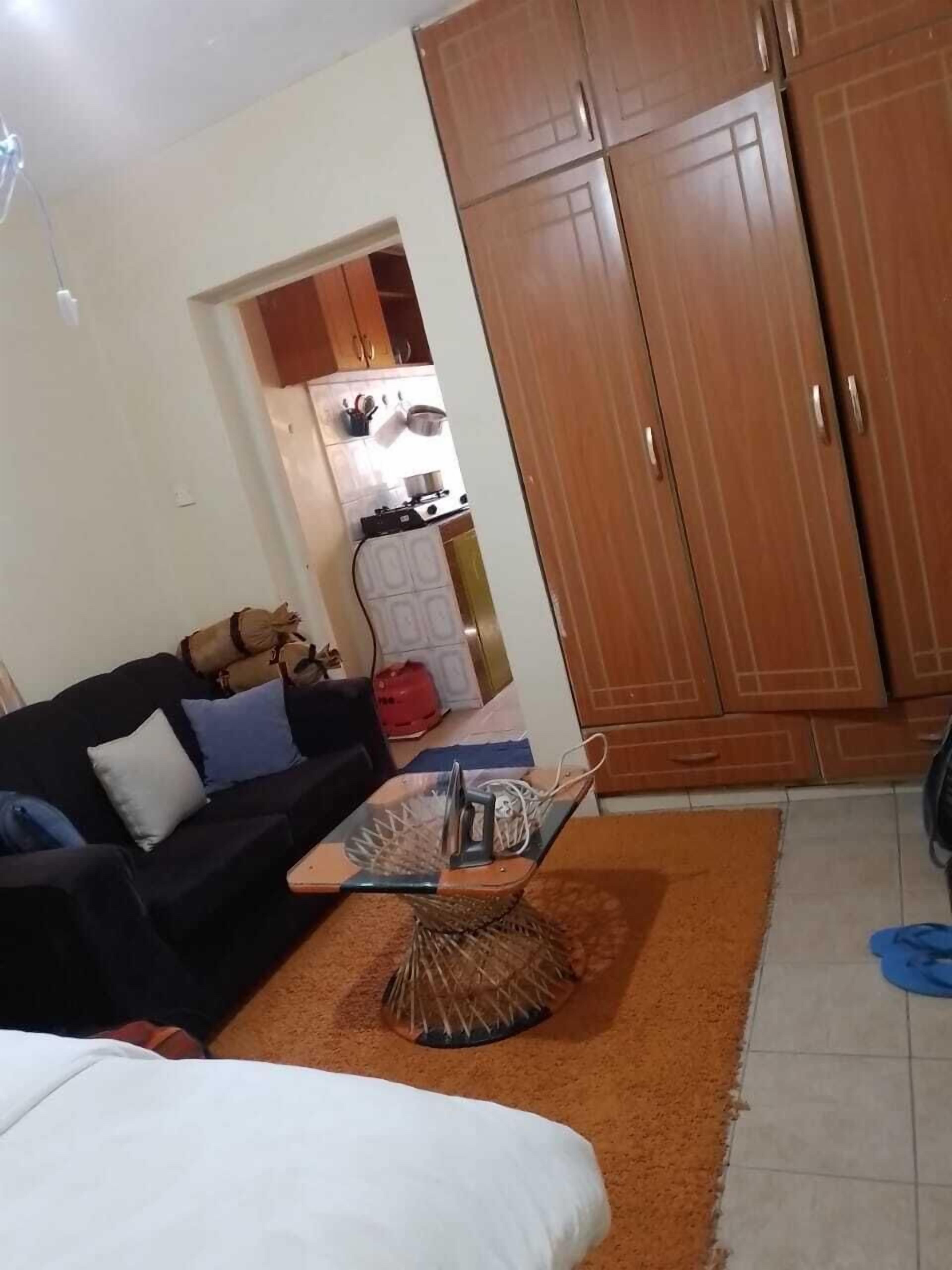 A living room with a sofa, a coffee table, and a wardrobe.