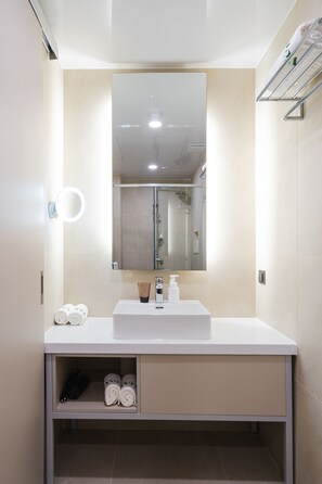 A modern bathroom with a white sink, a mirror, and a towel rack. - Hotel Vert (Seoul)