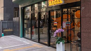 A hotel with a modern facade, a visible entrance, and a large sign for 'About Bagel'. - Hotel Vert (Seoul)