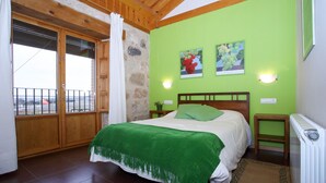 Un dormitorio con cama, ventana con vistas y radiador.