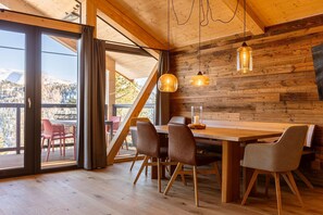 Enjoy meals with a view of the surrounding mountains from this dining area featuring a large table and comfortable seating.